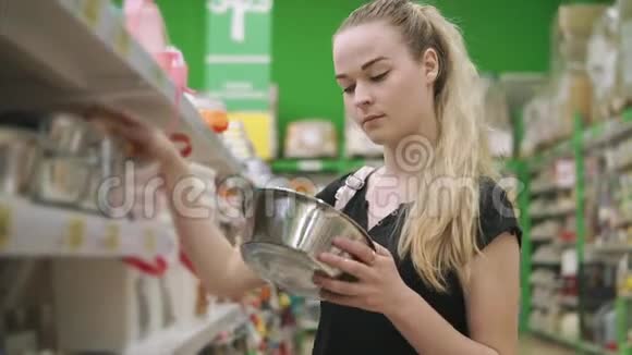 年轻的家庭主妇正在超市里为房子挑选金属盘子视频的预览图