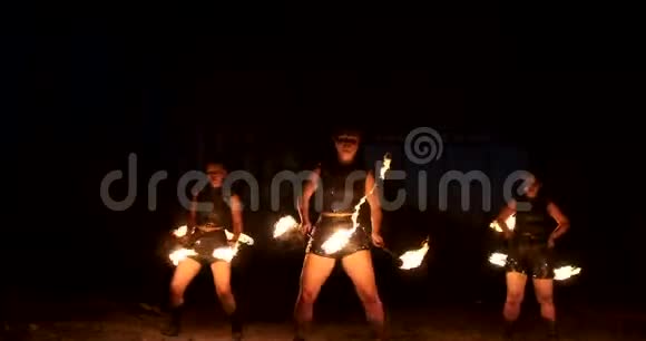 在飞机的老机库里举行专业的火灾表演表演专业的马戏团艺术家三个身穿皮衣的女人视频的预览图