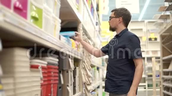 戴眼镜的成年人正在超市里打开一个新的塑料容器视频的预览图