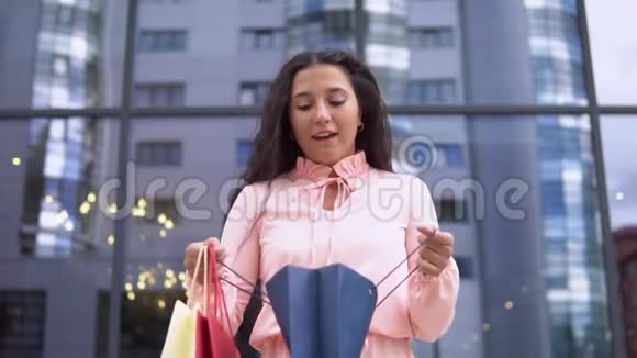 一个穿着粉红色裙子的年轻女孩购物后打开购物袋慢动作高清高清视频的预览图