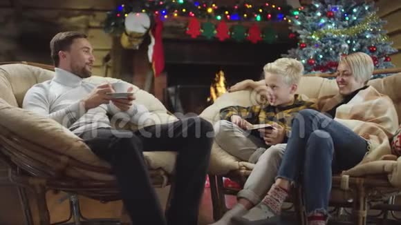 男人喝咖啡而小男孩在圣诞夜看书和他说话视频的预览图