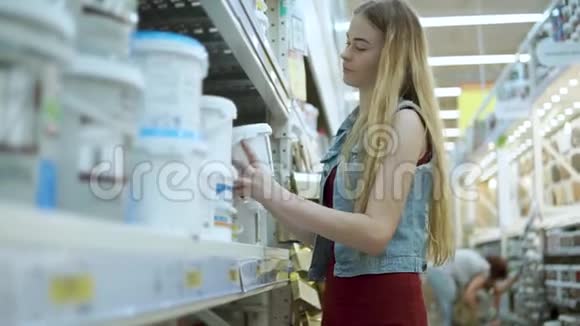 女设计师正在一家商店里用油漆检查罐子拿着不同种类的颜料视频的预览图