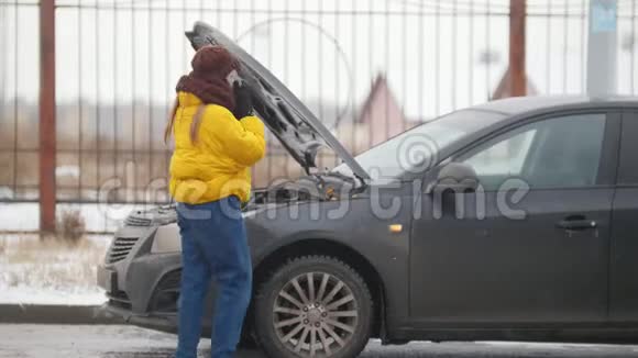 汽车故障冬天寒冷的天气一位年轻女子打电话到救援处寻求帮助视频的预览图