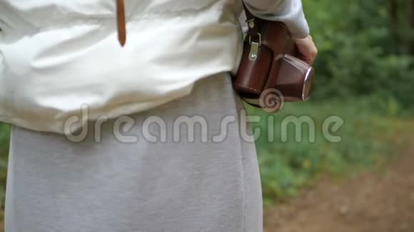 一个性格开朗的女人肩上拿着一个棕色盒子里的照相机视频的预览图