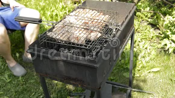 准备烤架上的生肉烧烤在阳光明媚的夏日野餐时他烤猪肉转烤架视频的预览图
