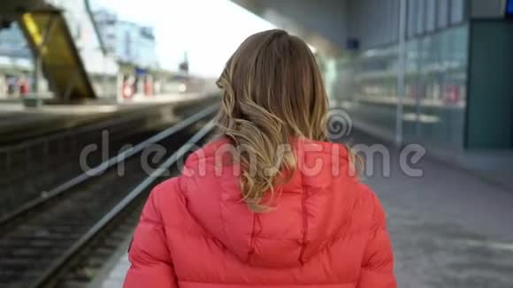 年轻女子在车站站台等车视频的预览图