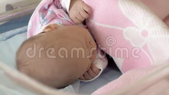 一个婴儿睡在粉红色毯子下面的特写镜头视频的预览图