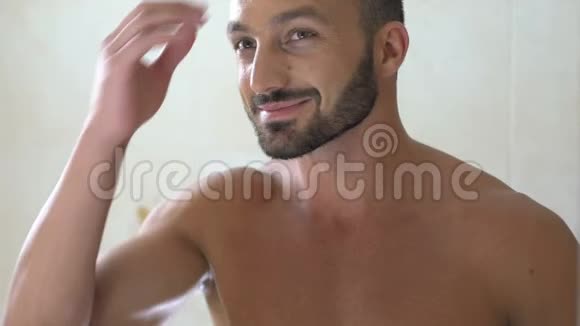 快乐的帅哥在浴室镜子前检查头发早上视频的预览图