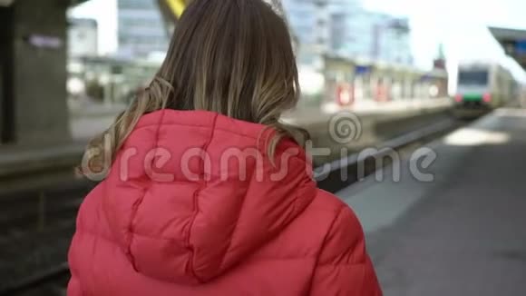 年轻女子在车站站台等车视频的预览图
