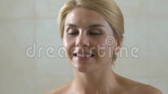 女人在浴室的脸上滴着化妆品油有益健康的酸视频的预览图