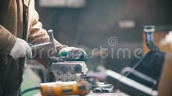 工业概念一名男子工人用铁锤敲击黑链子视频的预览图