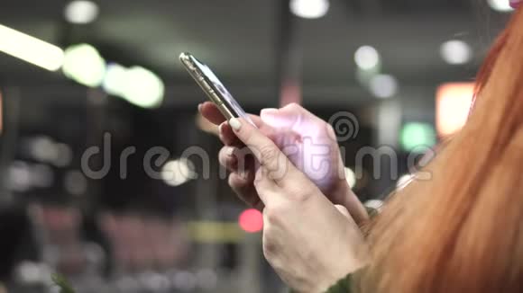 夜间城市使用智能手机的女性手部特写视频的预览图