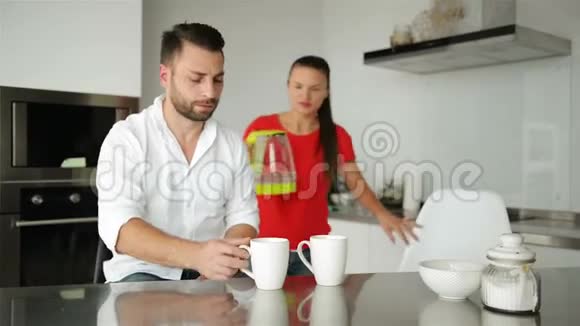 可爱的年轻夫妇在厨房里喝咖啡他们今天早上心情不错视频的预览图