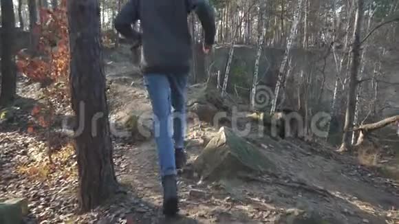 一个人手里拿着斧头在森林里危险的道路上飞快地奔跑视频的预览图
