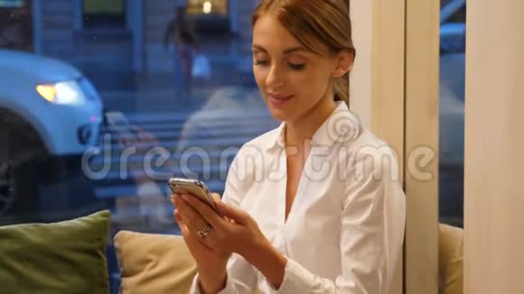有智能手机的商务女性在舒适的咖啡馆工作视频的预览图