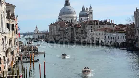 在威尼斯的大运河上在阿卡迪米亚区与圣玛丽亚大教堂的船只的早晨交通视频的预览图