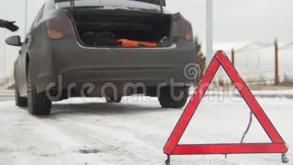 冬季驾驶汽车故障紧急信号在下雪的乡间小路上遇到了汽车故障一个年轻人叫救援人员视频的预览图