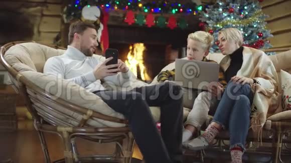 男人在圣诞节晚上给儿子和妻子看智能手机屏幕视频的预览图