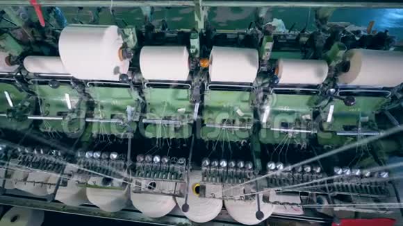 许多缝纫线轴在纺织厂机器上旋转视频的预览图