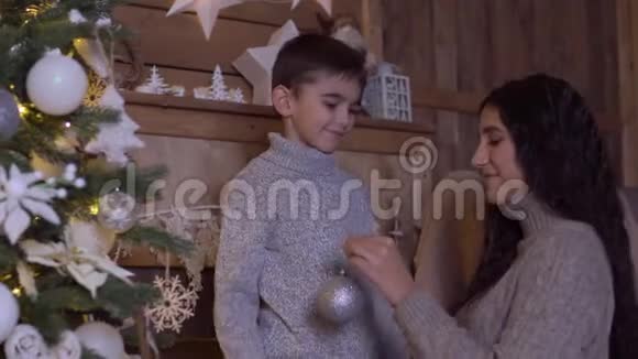 妈妈和儿子装饰一棵圣诞树心情很好4K视频的预览图