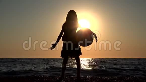 儿童在日落时玩沙滩球儿童在日落时看海浪女孩在日落时看风景视频的预览图