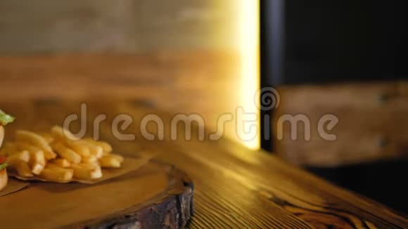 一个大的双人汉堡躺在薯条旁边的木板上专业烹饪的快餐视频的预览图