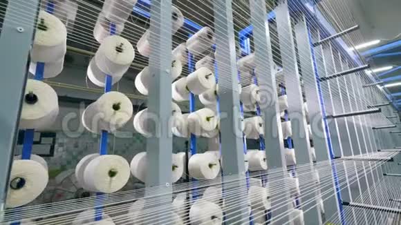 在纺织厂里一排排白色的绳子卷在线轴上视频的预览图