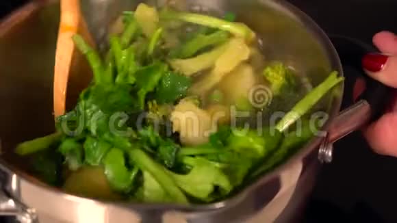 女人煮了一壶什锦新鲜蔬菜视频的预览图