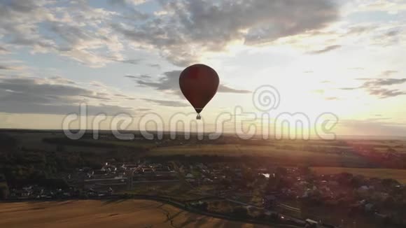 空中景色美丽的日落时分热气球在乡间田野上空盘旋视频的预览图