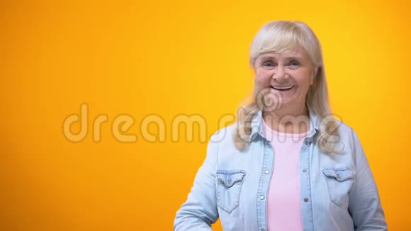 微笑的退休素食女士展示多汁的绿苹果有机食品节食视频的预览图