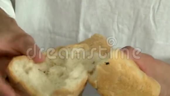 男人手打破一条新鲜面包视频的预览图