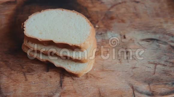 男性双手用钢刀将切好的白面包切白色面包人们早餐供应面包视频的预览图