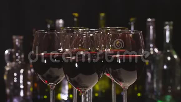 红酒优雅的酒杯背景是一排酒精瓶视频的预览图