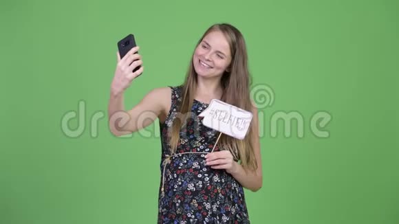年轻快乐的孕妇用纸签自拍视频的预览图