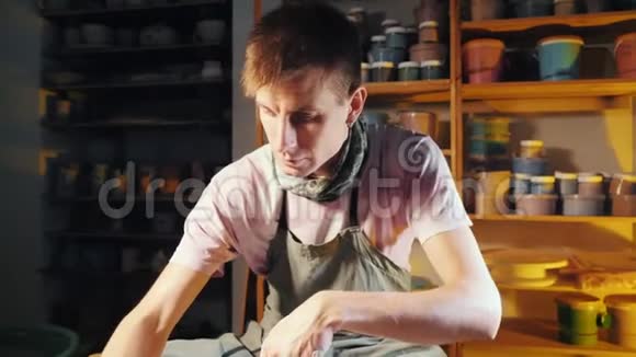 年轻英俊的艺术家操作手轻轻地创造正确形状的手工粘土传统陶器视频的预览图