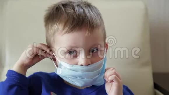 一个带面具的男孩的特写戴医疗面具的婴儿微笑视频的预览图