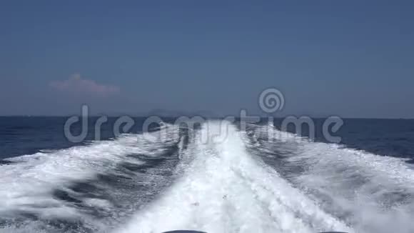 从一艘高速船的发动机上波浪后景蓝天白云和远岛视频的预览图