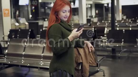 女旅客站在机场使用智能手机视频的预览图
