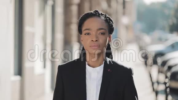时尚的非裔美国商务女性站在老街上交叉双手的肖像她看着视频的预览图