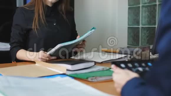 工作流程妇女在办公桌后讨论工作问题并在日常笔记中做视频的预览图
