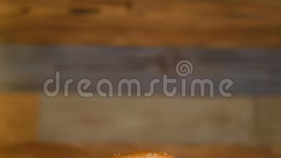 一块木头上放着一个汉堡里面有两块肉片和蔬菜不健康的食物专业烹调的快餐视频的预览图