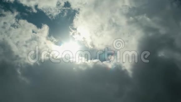 当一朵蓬松的白云接近时一幅宽射向上看着阳光在蓝色的天空中投射出一耀斑视频的预览图