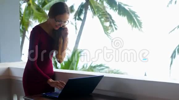 戴眼镜的长发女孩在露台上用笔记本电脑工作视频的预览图