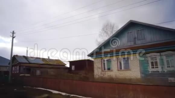 冬天开车穿过俄罗斯的一个村庄旧房子慢动作视频的预览图