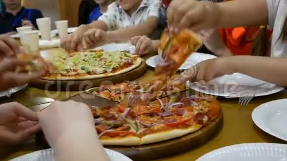 桌上有许多美味的披萨孩子们从盘子里拿出披萨视频的预览图