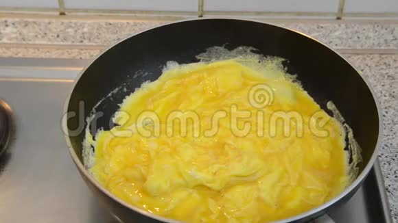 在家里用煎锅准备炒鸡蛋的人为健康的早餐做煎蛋卷烹饪美味有机和新鲜视频的预览图