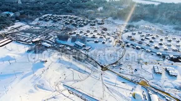 冬季在田野和森林中鸟瞰小村庄旅途冬天风景如画白雪覆盖视频的预览图