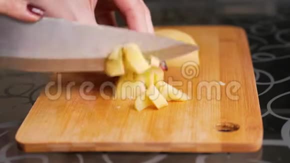 切煮土豆女人的手正在用一把大刀在木切割板上切煮土豆视频的预览图