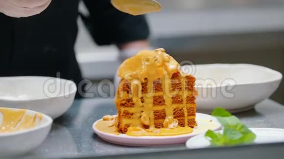 餐厅厨房在蜂蜜蛋糕的顶部倒入甜酱视频的预览图