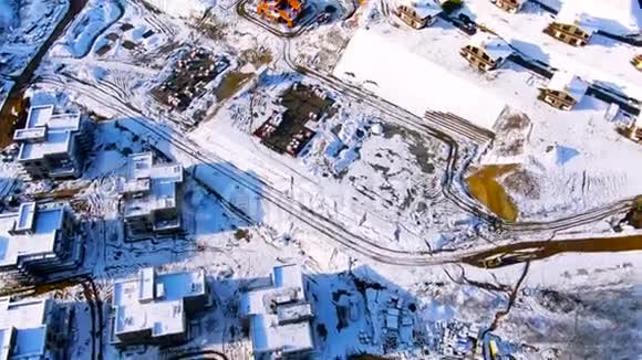在一个阳光明媚的冬日飞过被雪覆盖的城市工业区旅途美丽房屋的空中楼阁视频的预览图